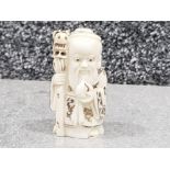 Japanese handcarved bone Netsuke in the form of village seer with shaman staff