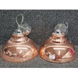 A pair of industurial style copper effect ceiling light fittings.