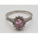 9ct white gold pink stone cluster ring featuring an oval pink stone in the centre surrounded by