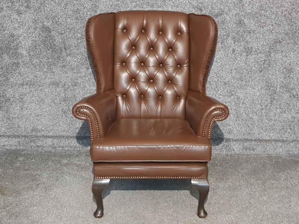 Brown leather metal studded wing back armchair, button back with mahogany feet