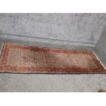 A Persian wool runner with red border 195 x 75cm.