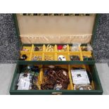 Green jewellery box containing a variety of costume jewellery pieces