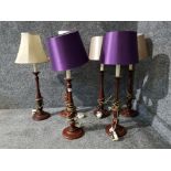 A set of six wooden style table lamps with various shades.