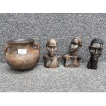 Three carved wooden African busts and an earthern ware two handled cooking pot