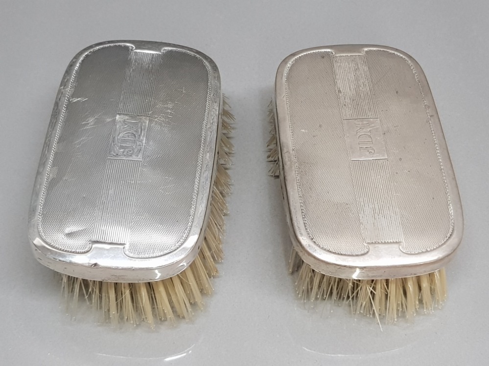 A pair of silver backed hair brushes hallmarked for Birmingham
