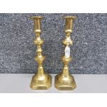 A pair of antique brass king of diamond pattern candlesticks 28cm high