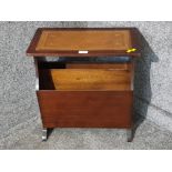 A mahogany magazine rack with leather inset top