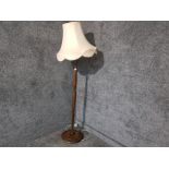 A stained beach standard lamp with peach tasseled shade