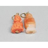 Two oriental carved pendants of figures, one coral and the other agate.