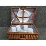 Vintage wicker picnic hamper containing plastic cups, plates & cutlery