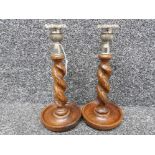 A pair of oak barley twist pattern candlesticks with metal mounts 26.5cm high