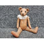 A resin teddy bear with articulated limbs