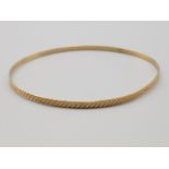 A 9ct yellow gold bangle with engraved decoration 1.7g
