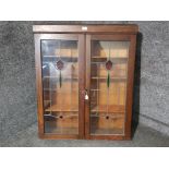 An edwardian oak bookcase with stained leaded glass panels, with three shelves
