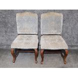 Pair of metal studded upholstered chairs on mahogany foot supports