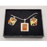 A silver and amber type pendant on silver chain, together with a pair of similar earrings.