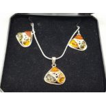 A silver and amber type pendant on chain together with matching earrings