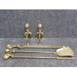 A brass part fireside companion set to include andirons and poker with claw and ball handles