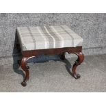 A Victorian footstool upholstered in grey check material raised on cabriole legs