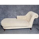 A 20th century chaise long upholstered in beige leaf patterned material with 2 brass castors