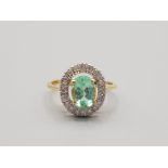 Ladies 18ct yellow gold green stone and diamond cluster ring comprising of a oval green stone