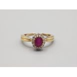 Ladies 9ct yellow gold ruby and diamond cluster ring comprising of a oval ruby in the centre