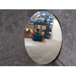 An oval bevelled wall mirror 89 x 60cm