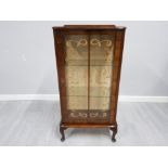 A walnut veneer display cabinet with glazed door raised on cabriole legs (key)