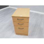 A laminate filing cabinet with three drawers