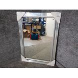 A bevelled glass wall mirror with glass frame and box detailing to corners 105 x 75cm