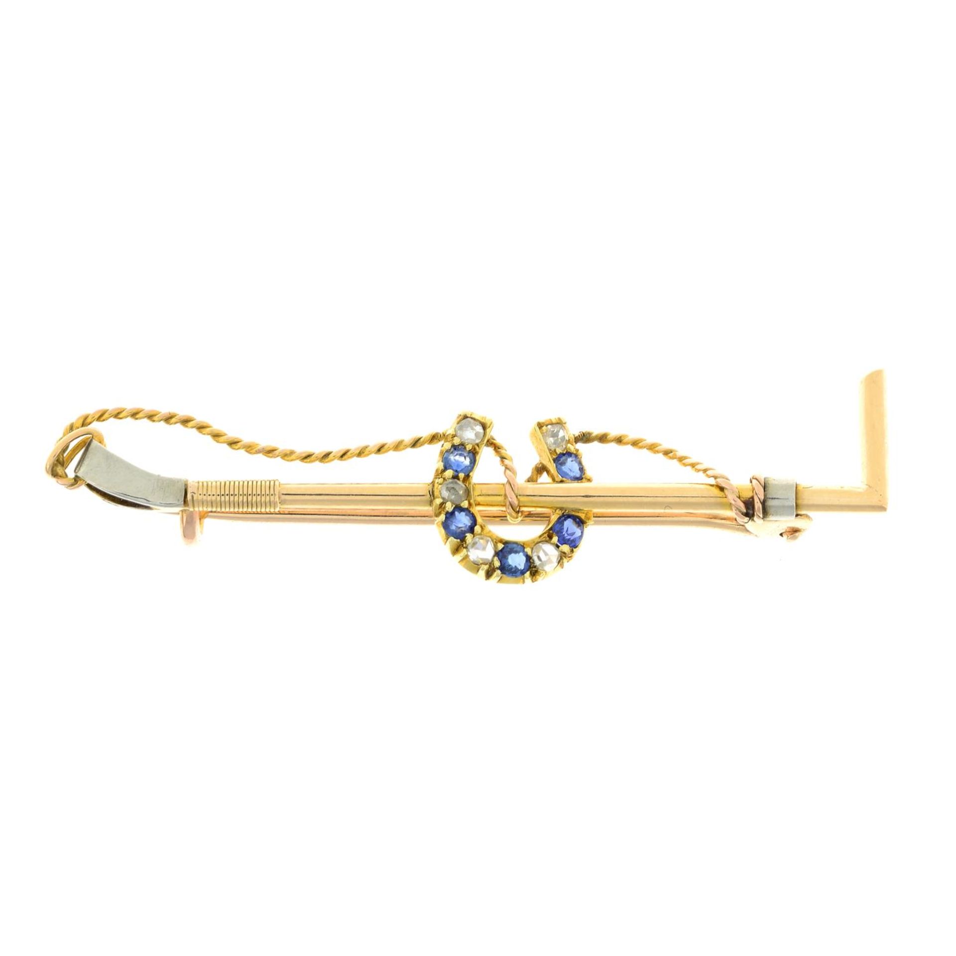 An early 20th century gold sapphire and rose-cut diamond horseshoe and riding crop brooch.Length