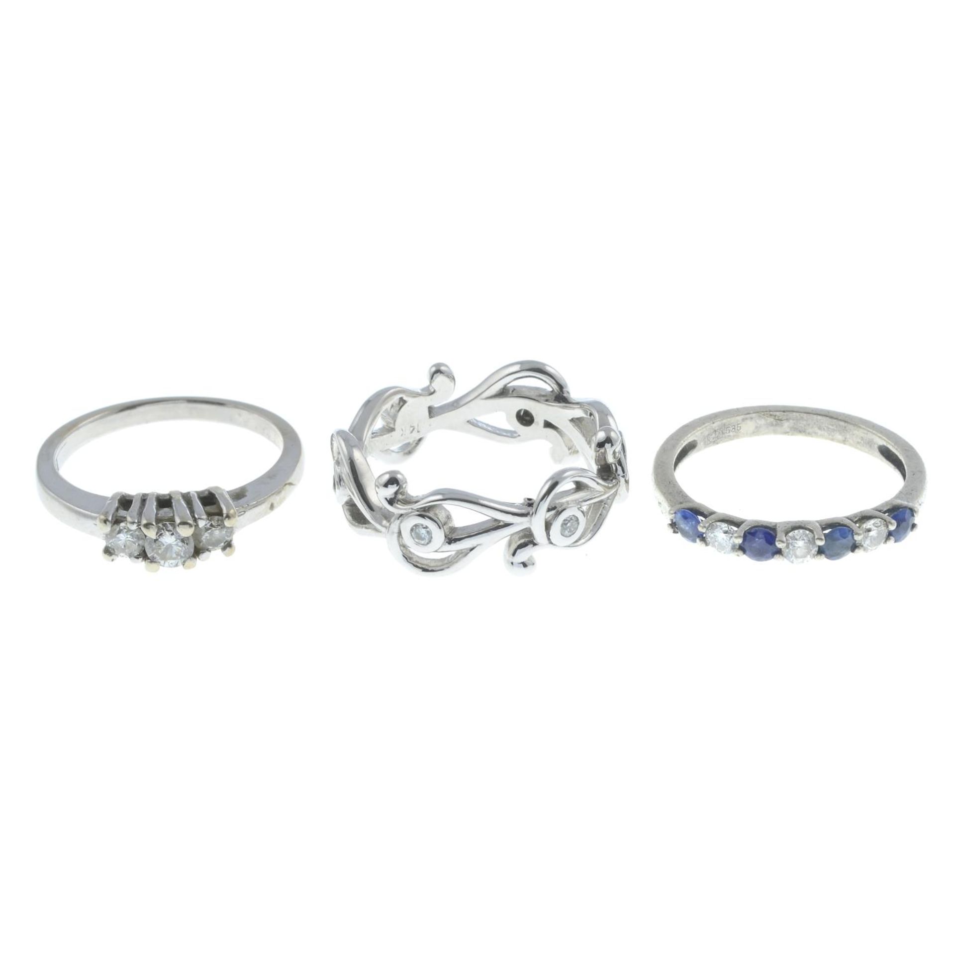 Three gem-set rings.Brilliant-cut diamond three-stone ring,