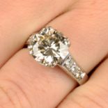 A brilliant-cut diamond single-stone ring, with pavé-set diamond shoulders.