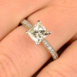 A platinum square-shape diamond single-stone ring, with pavé-set diamond line shoulders.