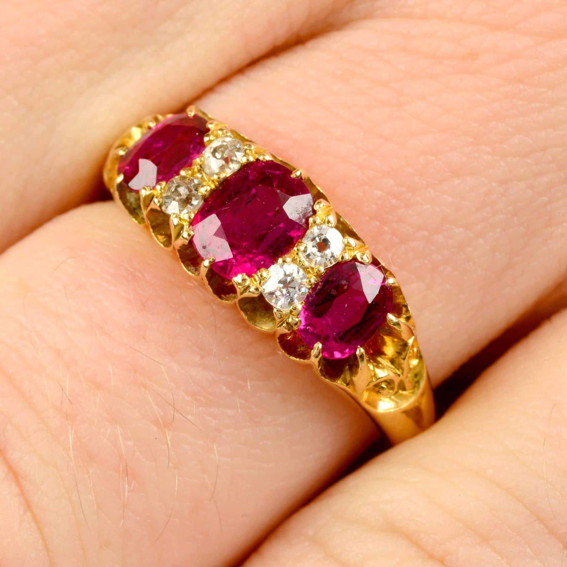 An Edwardian 18ct gold Thai ruby three-stone and diamond ring.Verbal from GCS,