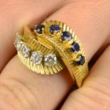 A 1960s sapphire and diamond crossover dress ring.Estimated total diamond weight 0.60ct,