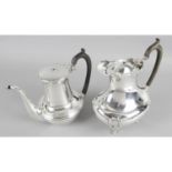Two early 20th century silver hot water jugs - one of round bulbous plain form with swan neck spout