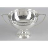 An early twentieth century silver twin-handled cup with pierced floral rim standing on a plain