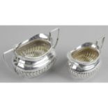 An Edwardian silver twin-handled sugar bowl and matching cream jug,