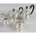 A modern silver four piece tea set of round bulbous form with pie crust decoration standing on