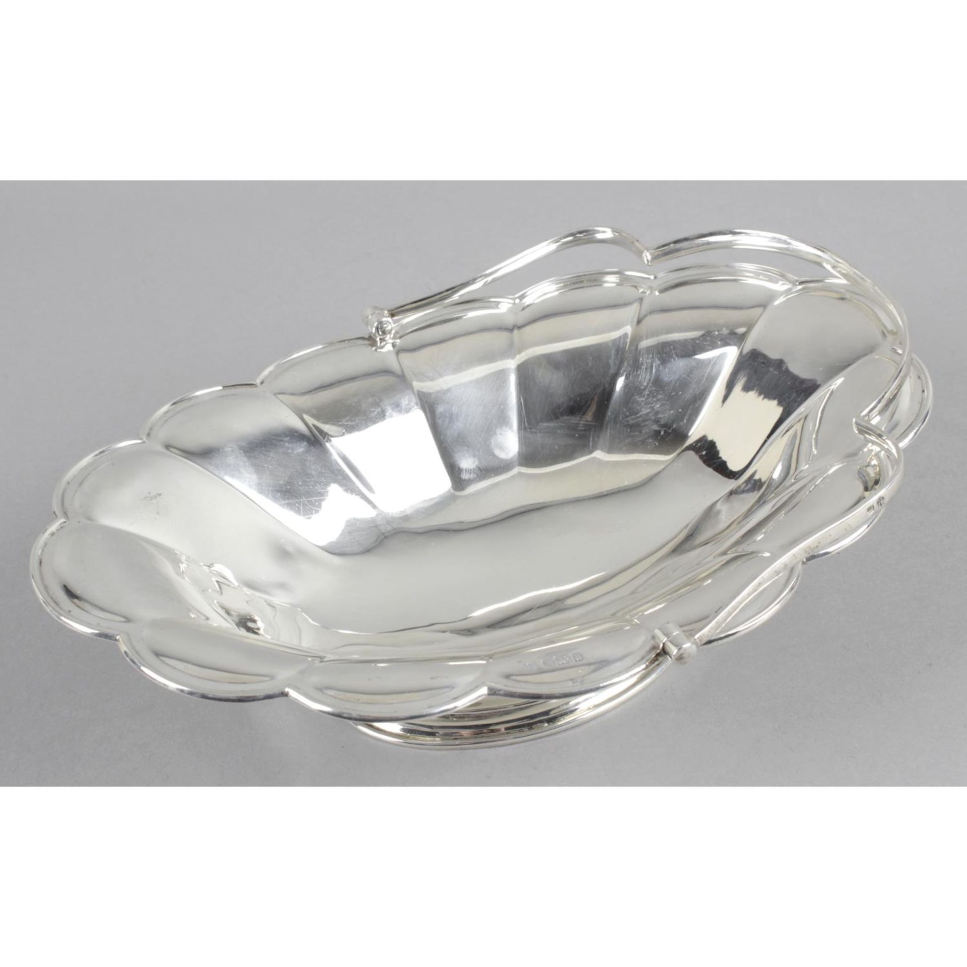 Early 20th century silver swing handle basket of oval shape with shaped rim and panel sides