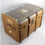 An old brown canvas and wooden bound travel trunk with applied Hogwarts crest to top and H.P