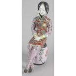 An unusual Oriental pottery figure modelled as a lady wearing traditional dress,