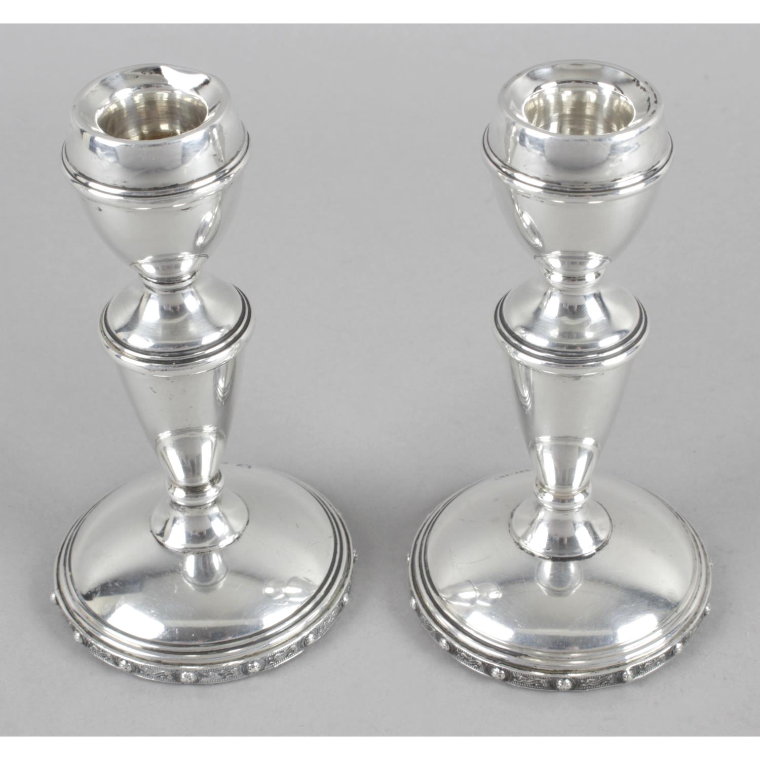 A pair of small silver candlesticks,