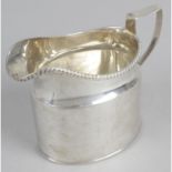 A late George III silver cream jug, of plain ovoid form with oblique gadroon rim and short spout.