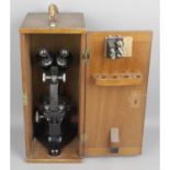 An R & J Beck Ltd, black pained binocular microscope in fitted carry case.
