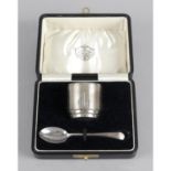 A cased 1930's silver egg cup and spoon set,