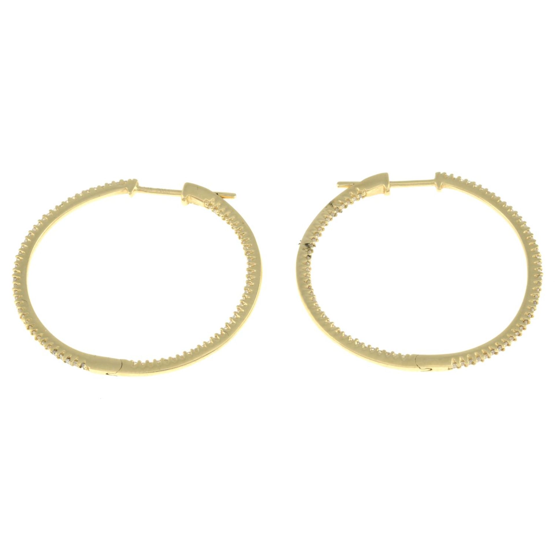 A pair of diamond hoop earrings.Total diamond weight 0.53ct, stamped to mount.