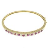 A 9ct gold ruby and diamond bangle.Estimated total diamond weight 0.15ct.