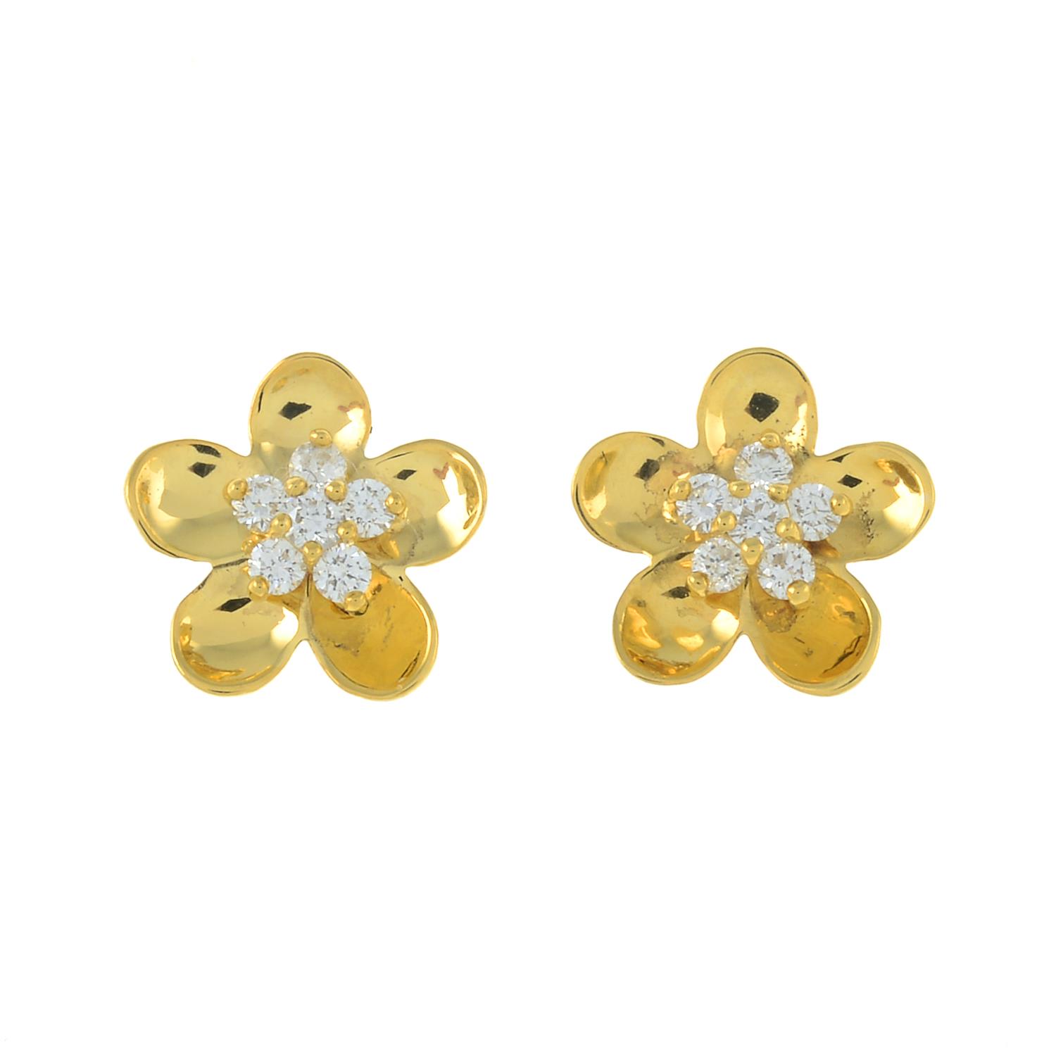 A pair of diamond accent floral stud earrings.Estimated total diamond weight 0.25ct.